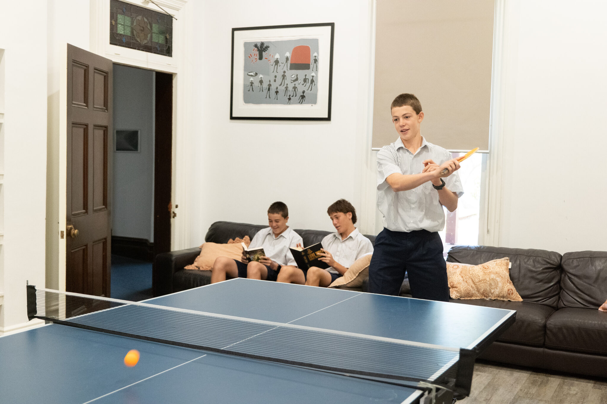 Students playing pool and reading in the Walters Boarding House common room