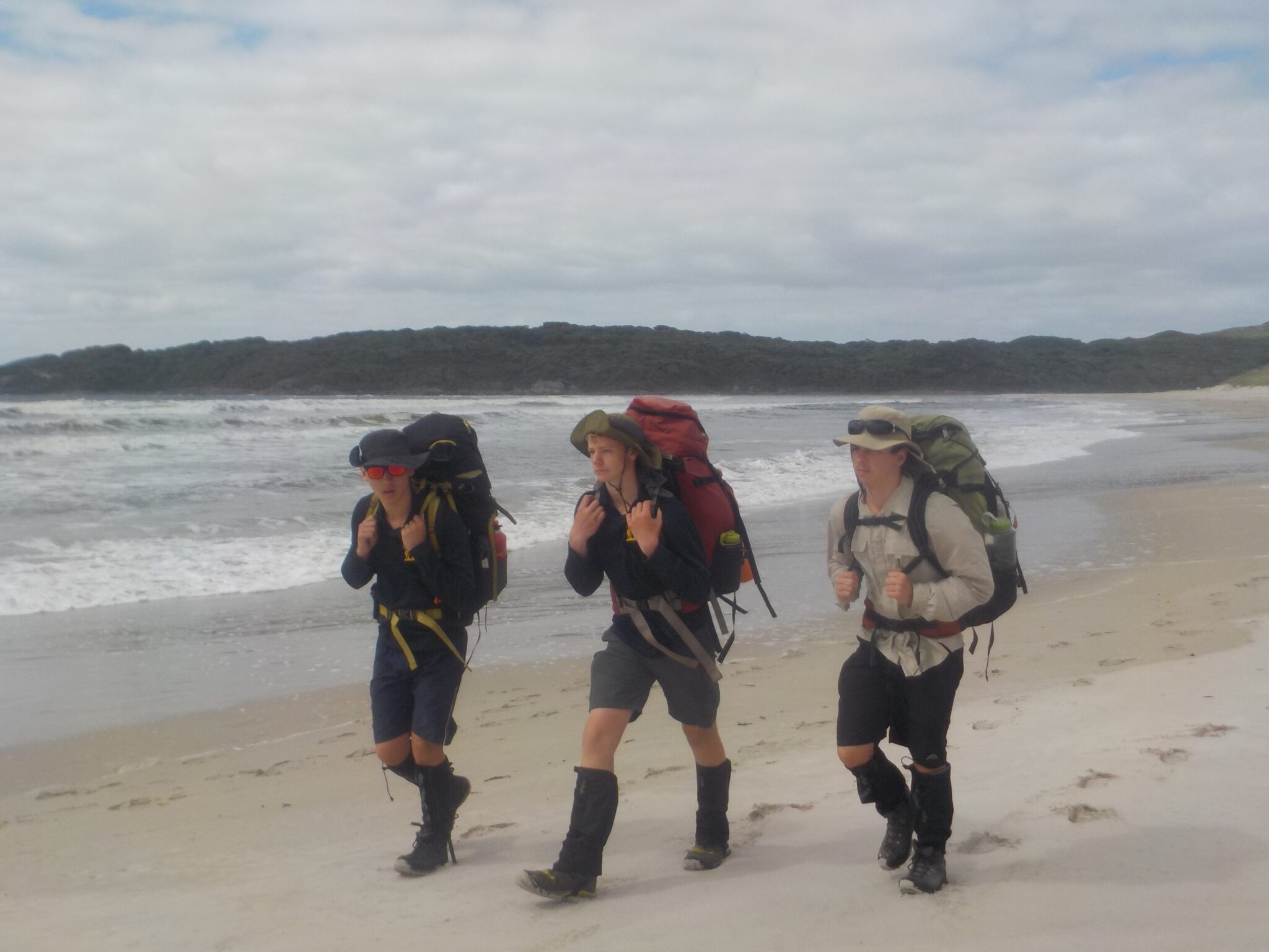 Year 10 students hiking across a beach as part of Year 10 venture Outdoor Education program