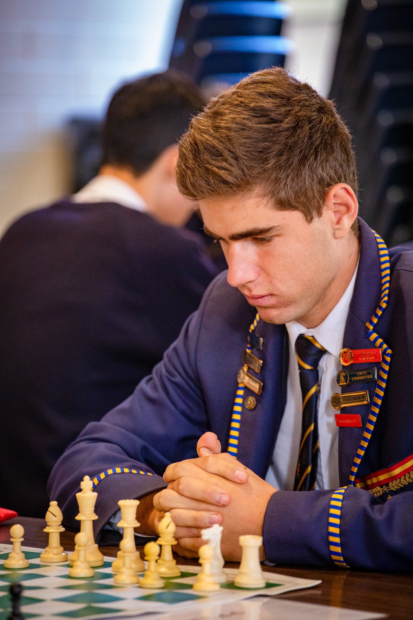 A student concentrating on a chess board