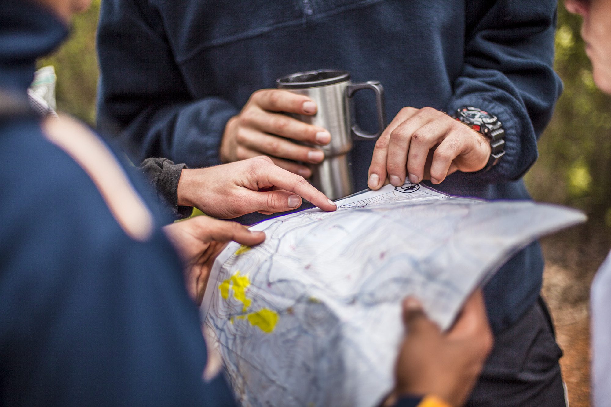 Students and staff pointing at a map during an outdoor education program