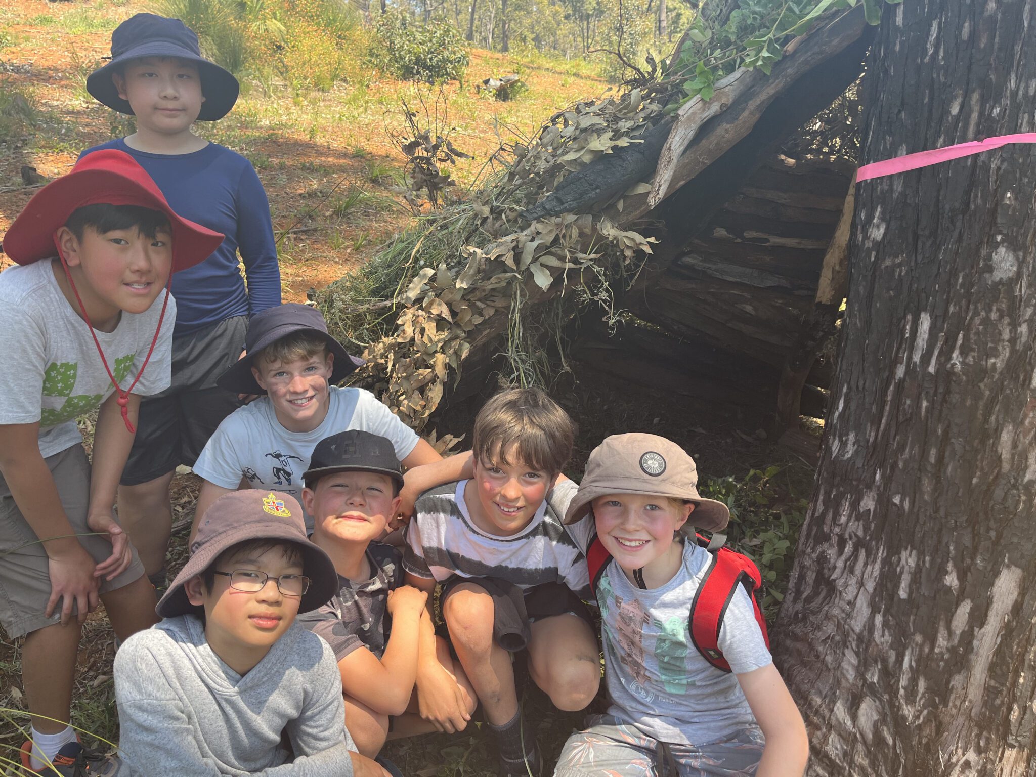 Year 5 students near a lean-to hut they built during their Outdoor Education Experience at Kooringal