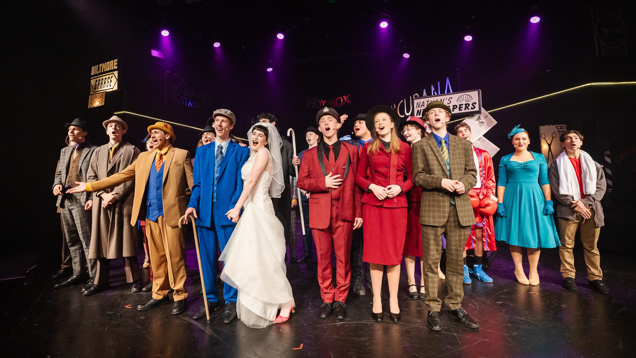 The cast of Guys and Dolls centre stage singing