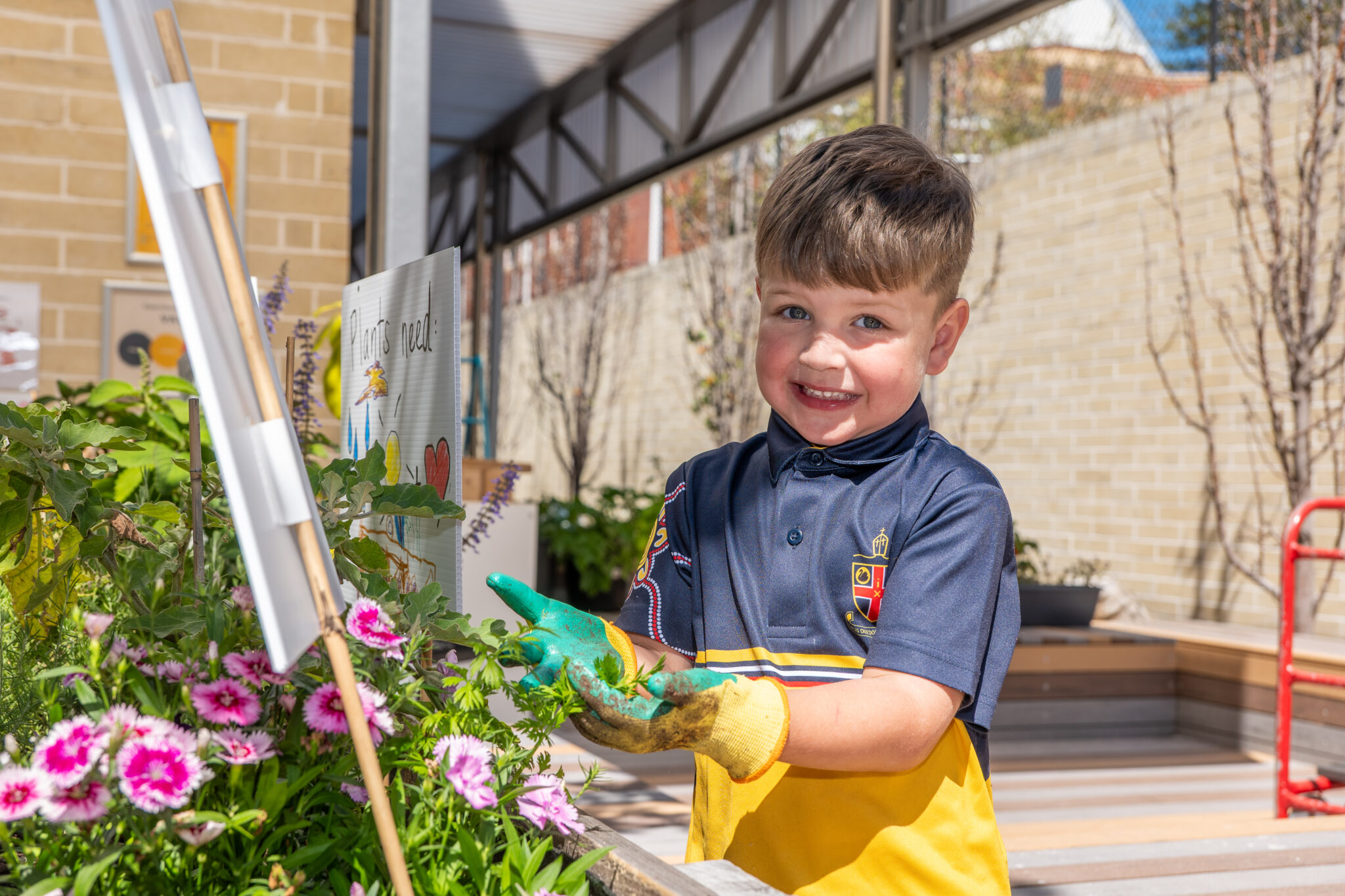 An Early Learning Community student cradling a flower in their hands