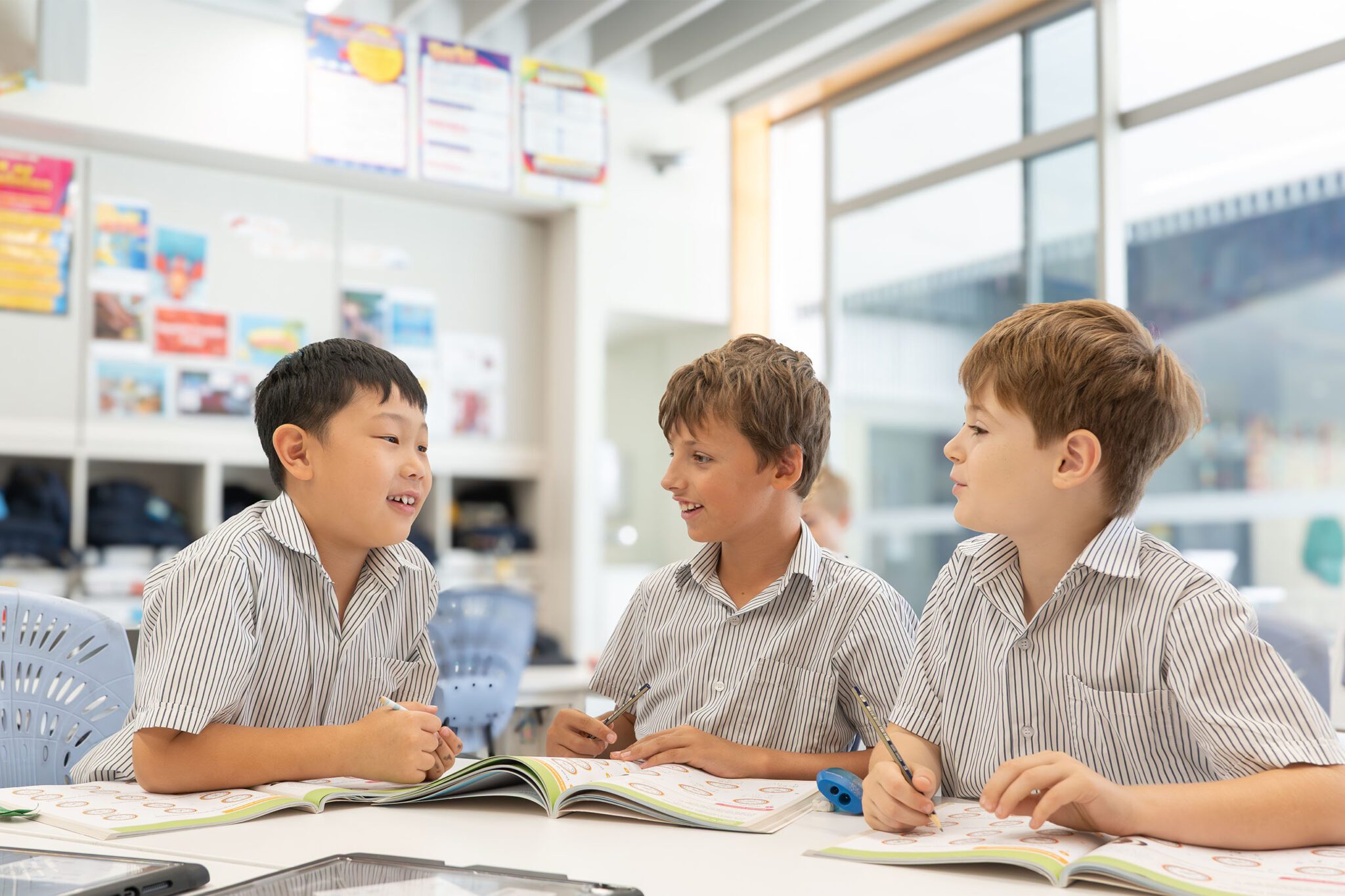 Three students talking together in a group exercise in a classroom