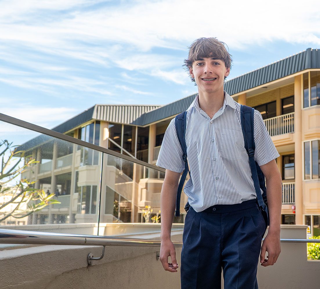 Year 10 Senior School student smiling while walking with school bag