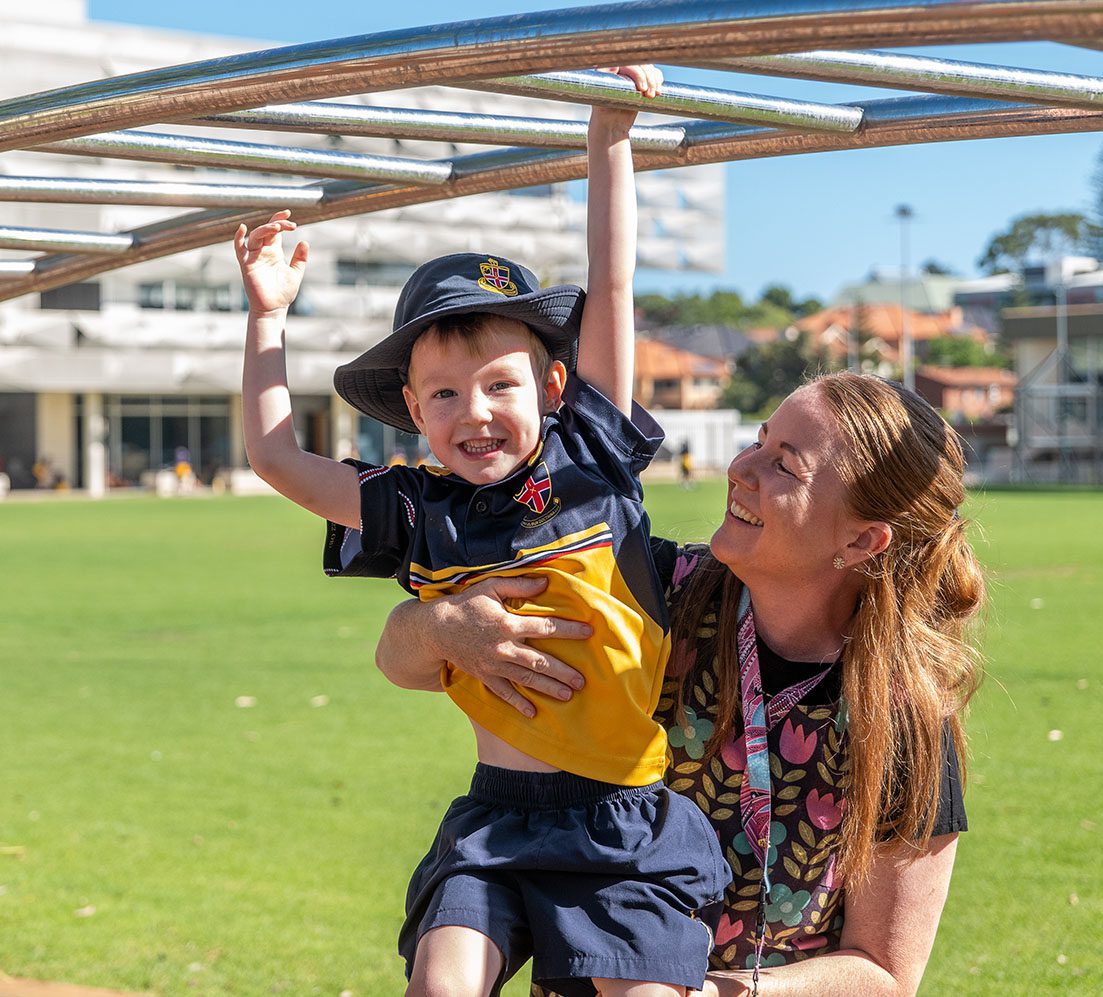 Teacher helping student in the playground.