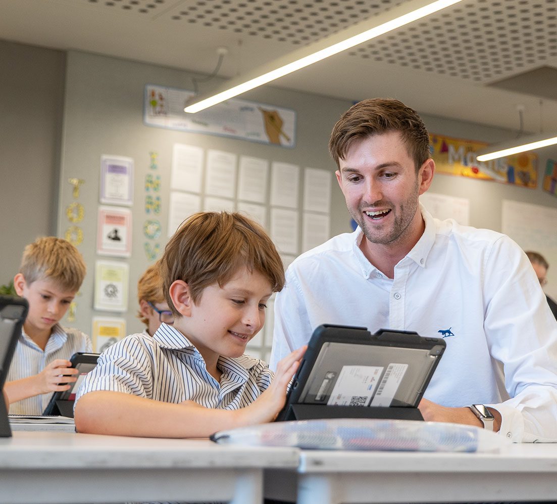 Year 6 student showing a teacher their class work.