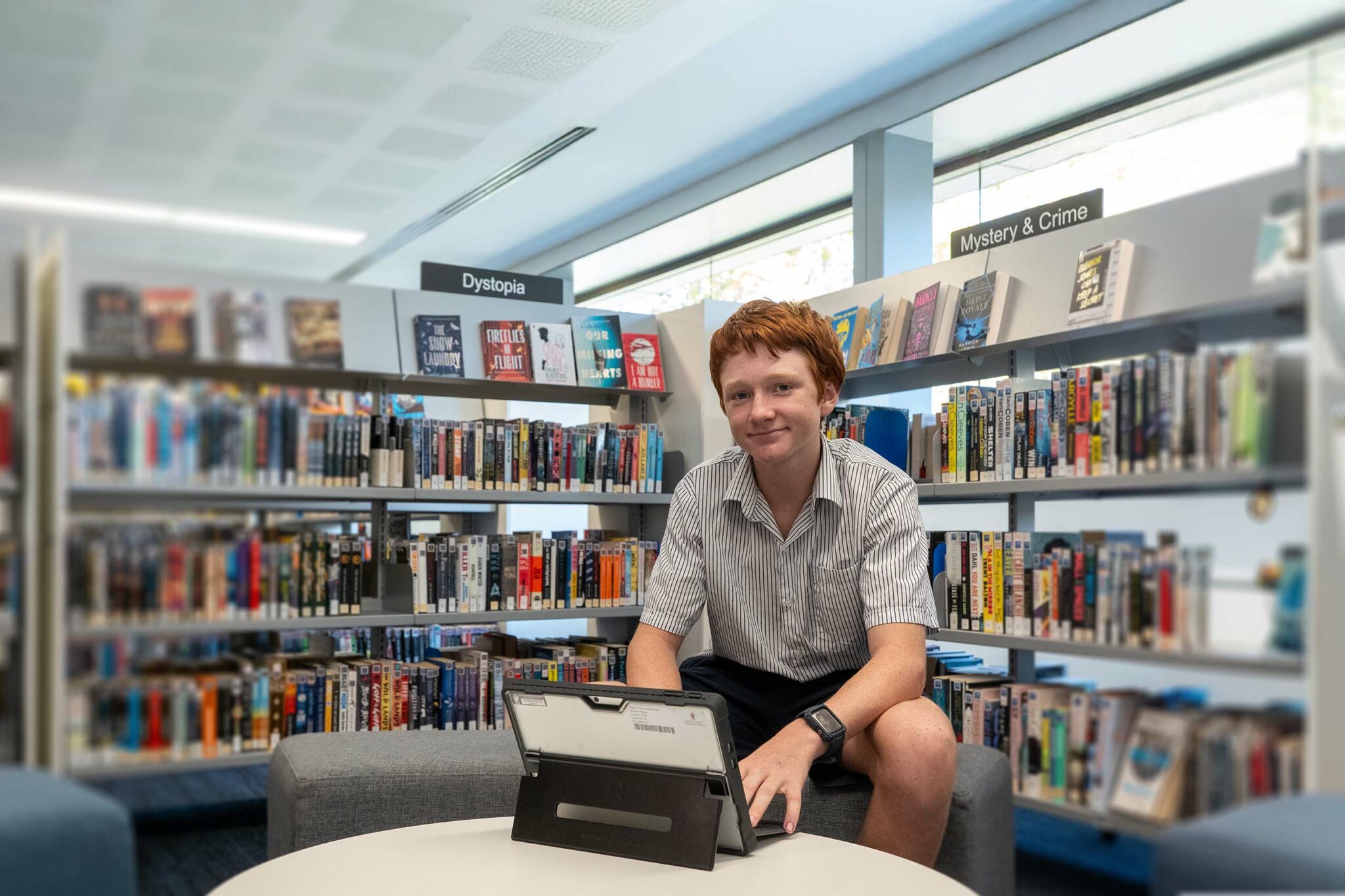 Student smiling while working on a project in the Academic Resource Centre and Library