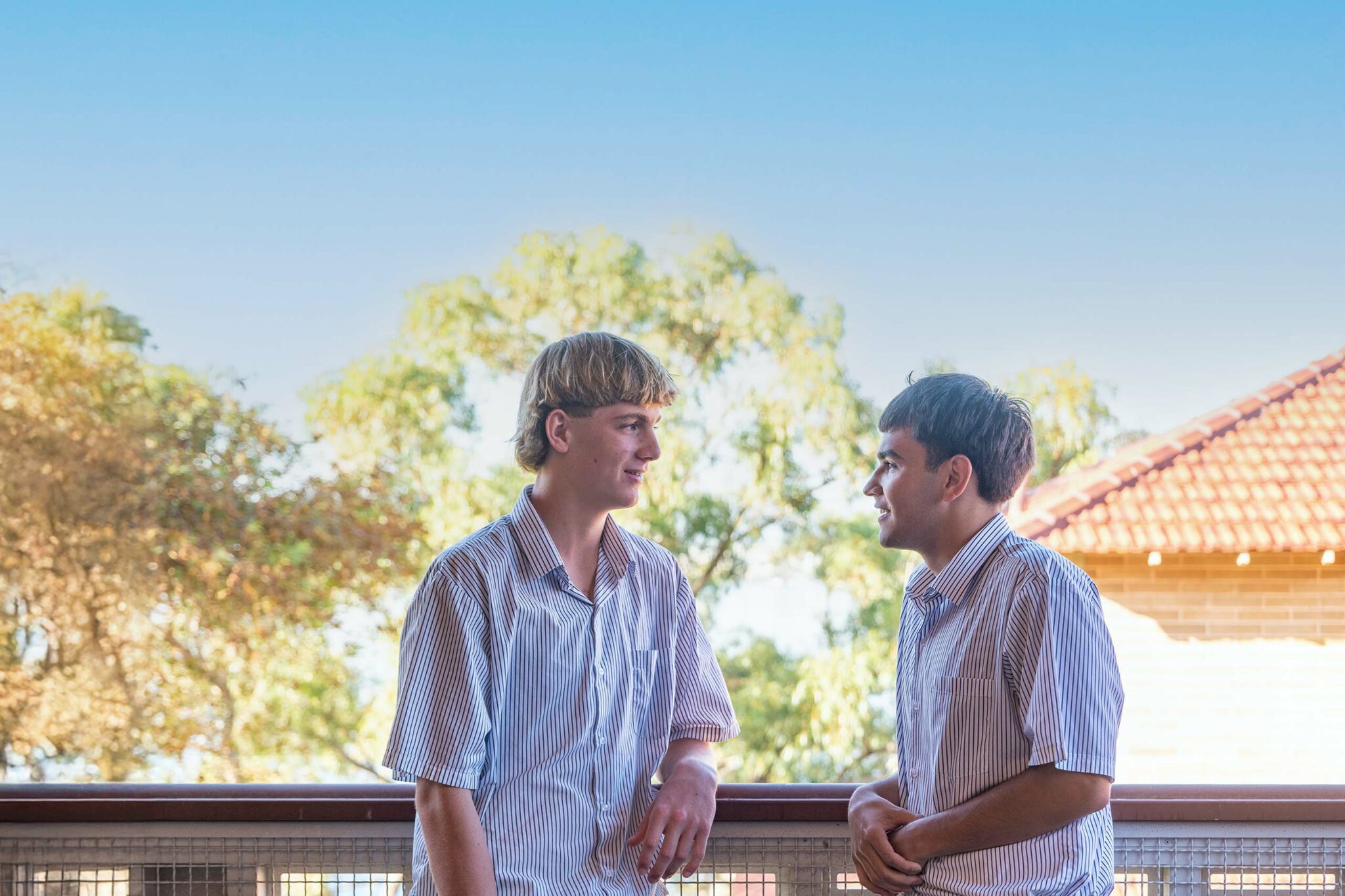 Two boarding students having a discussion on a balcony