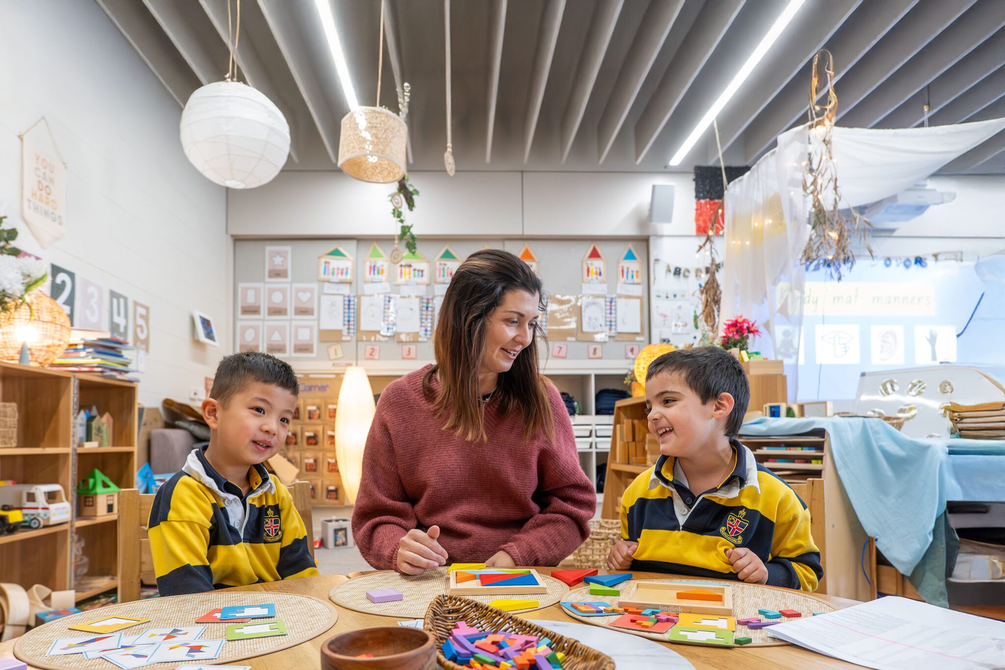 Teacher smiling at two Kindergarten students