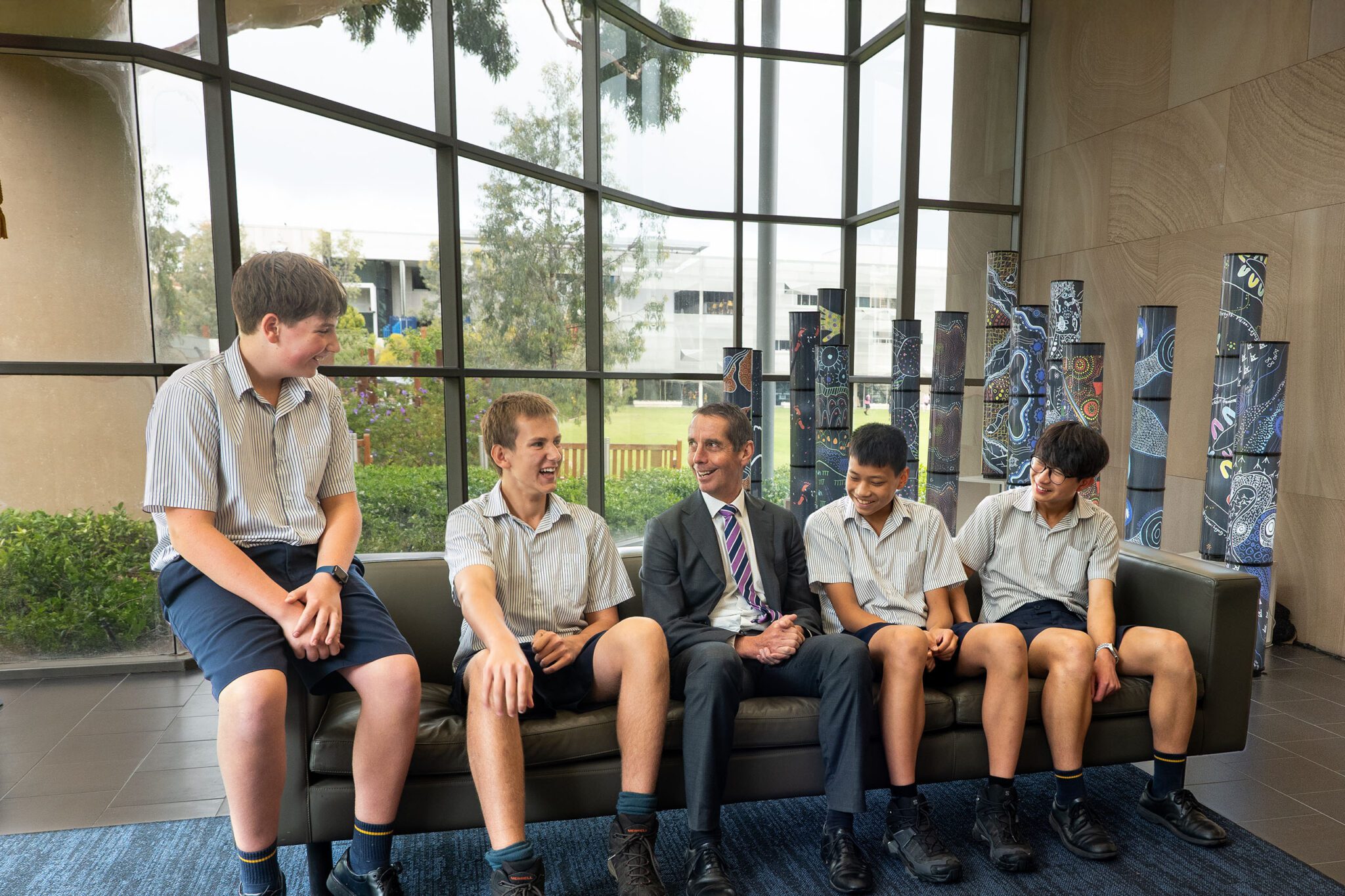 Principal Alan Jones talking with students in the Main Administration building foyer
