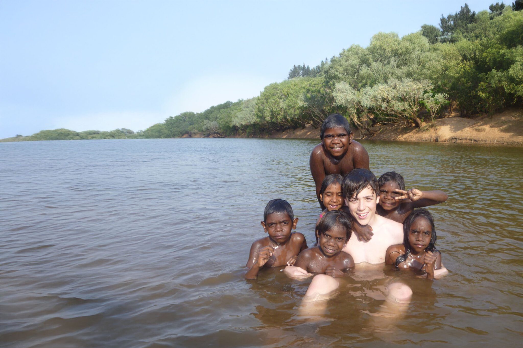 Group of kids in the water during a Service in Action tour