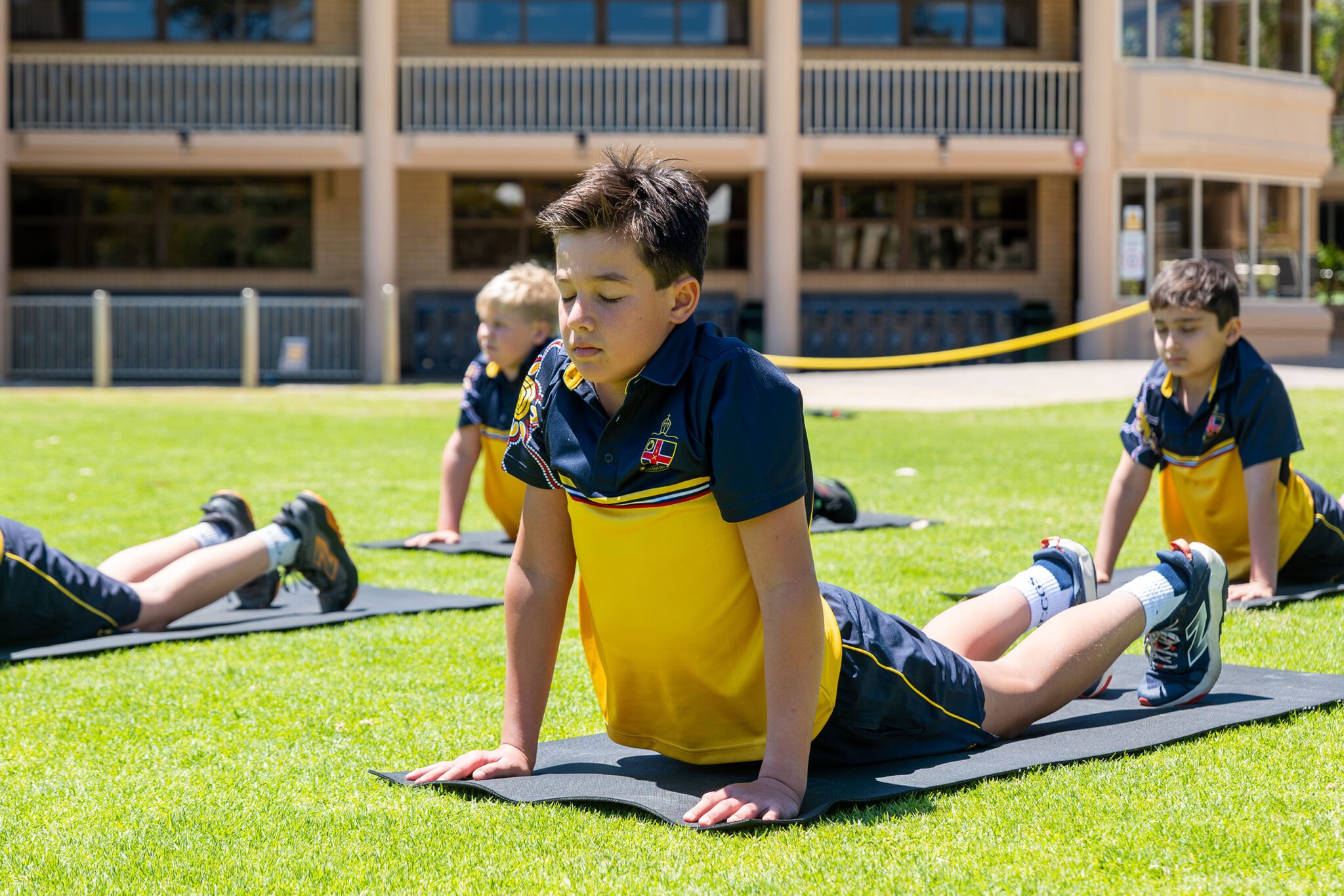 Students doing yoga on the school oval