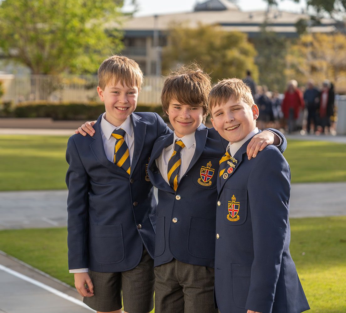 3 students smiling outside Chapel